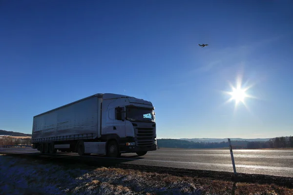 Lastbilstransporter på vägen vid solnedgången på vintern — Stockfoto