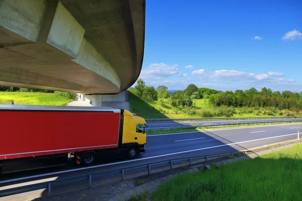 Перевозка грузовиков по дороге под мостом — стоковое фото