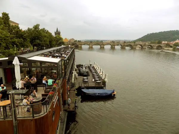 Prag 'da ziyaretçiler ve Charles Köprüsü ile küçük bir kafe. Yaz, 2017 yıl. 