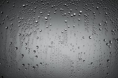 büyük ve küçük su damlaları siyah ve beyaz bir yüzey üzerinde.