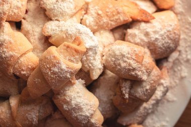 Küçük boy ev yapımı simitler, üzerine şeker serpiştirilmiş reçel serpiştirilmiş.