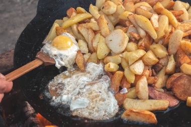 Açık ateşte yumurtalı patates pişirmek.