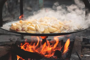 Açık ateşte yumurtalı patates pişirmek.
