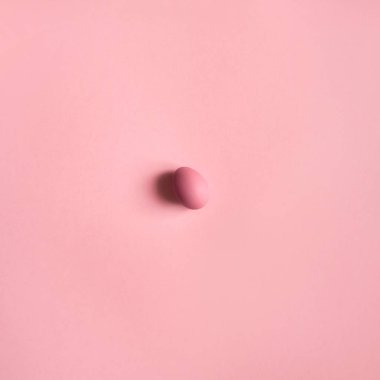 Ortada pembe yumurta üstten görünüm pembe bir arka plan üzerinde