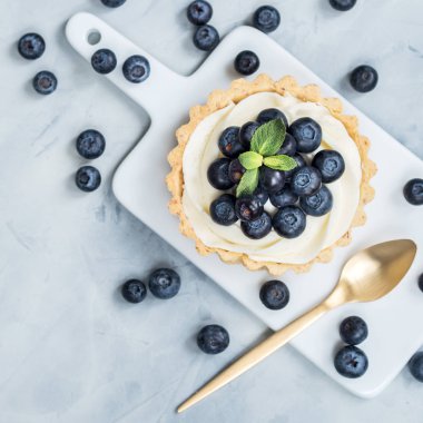 Işık arka plan üzerinde yaban mersini çilek ile vanilya tartlets