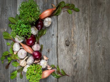 otlar, soğan ve sarımsak ahşap yüzeyi ile sebze kompozisyon