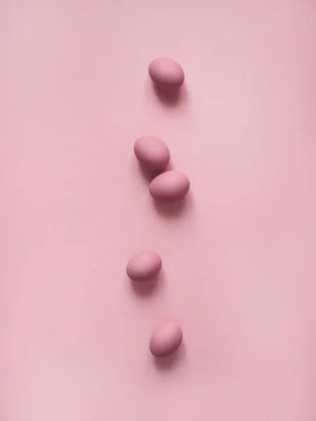 Top view of pink eggs on pink background