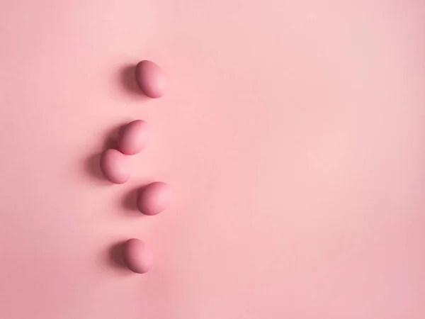 Top view of pink eggs on pink background