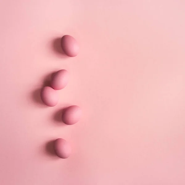 Top view of pink eggs on pink background