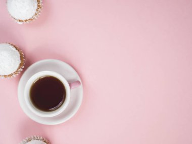 Pembe bir arka plan üzerinde kahve fincanı ve cupcakes Üstten Görünüm
