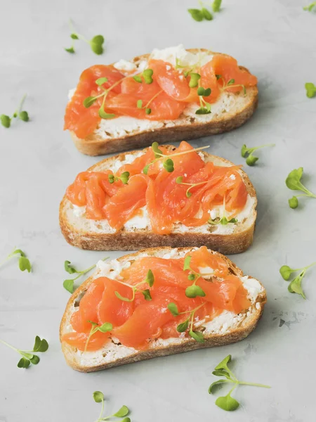 Fresh French baguette served with goat cheese, salmon and herbs on marble table