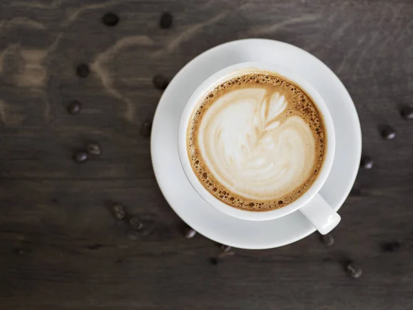 咖啡籽木桌上的新鲜卡布奇诺 — 图库照片