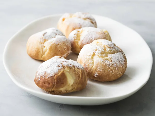 Meghintjük Porcukorral Szolgált Fehér Tányérra Torta Profiteroljáról — Stock Fotó