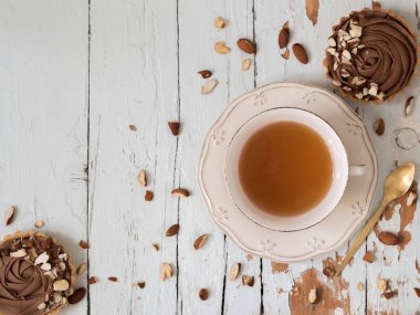 Badem fındık ahşap arka plan üzerinde çay ile servis ile Çikolatalı tart Üstten Görünüm