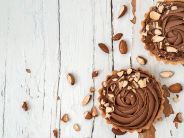 Badem fındık ile Çikolatalı tart üstten görünüm beyaz tahta yüzeyi