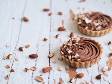 Beyaz ahşap yüzeyde badem fındık ile Çikolatalı tart Görünümü Kapat