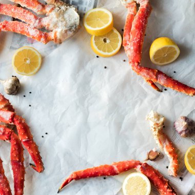 Buruşuk kağıt üzerinde taze Yengeç bacakları limon ve baharat ile Üstten Görünüm