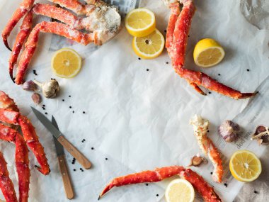 Buruşuk kağıt üzerinde taze Yengeç bacakları limon ve baharat ile Üstten Görünüm