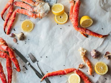 Buruşuk kağıt üzerinde taze Yengeç bacakları limon ve baharat ile Üstten Görünüm