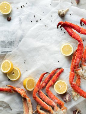 Buruşuk kağıt üzerinde taze Yengeç bacakları limon ve baharat ile Üstten Görünüm