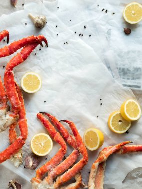 Buruşuk kağıt üzerinde taze Yengeç bacakları limon ve baharat ile Üstten Görünüm