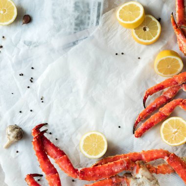 Buruşuk kağıt üzerinde taze Yengeç bacakları limon ve baharat ile Üstten Görünüm