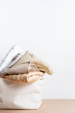Çamaşır sepetinde temiz kıyafetler. Mesaj için yer var. Biyoorganik ürün düzeni.