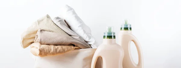 白い背景に洗濯用洗剤のモックアップ用エコデザインボトル包装で折り畳まれたきれいな服の山 テキスト用のスペース バイオ有機製品のレイアウト — ストック写真