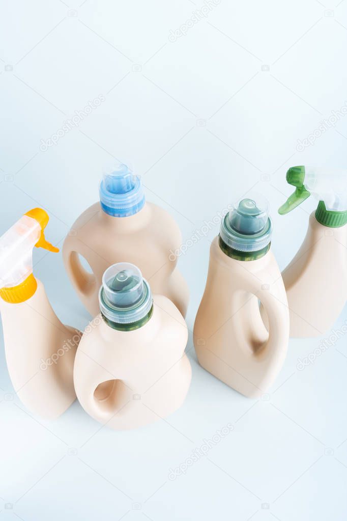 Set of blank label bottles for mockup packaging of cleaning detergent on blue white background. Cleaning tools, cleanliness and cleaning layout.