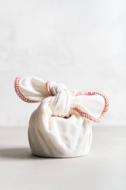 Kolay taşınan eşyalar için Asya tekniği. Beyaz keten çanta düğümlenmiş..