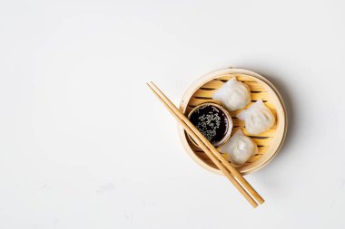 Geleneksel Çin usulü hamur köfteleri bambu buharlı buharlı, soslu ve yemek çubuklarıyla fotokopi alanlı. Asya gıda geçmişi.