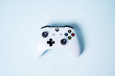 Moskova, Rusya - Juney 03 2019: Beyaz Kablosuz Oyun Alanı Xbox One S kontrol kolu mavi pastel arka planda fotokopi alanı ile. Yaratıcı Asgari Oyun konsepti.