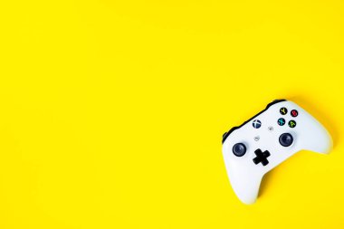 Moskova, Rusya - Juney 03 2019: Beyaz kablosuz oyun konsolu Xbox One S kontrol kolu üzerinde fotokopi alanı ile sarı arka plan. Yaratıcı Asgari Oyun konsepti.