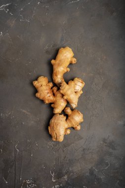 Koyu arkaplanda zencefil kökü ve kopyalama alanı. Üst görünüm.