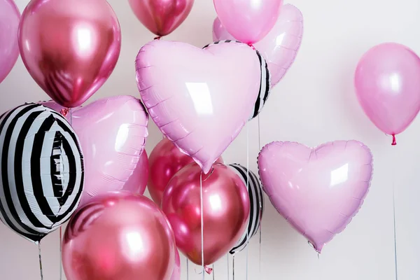 Set of balloons in the form of a heart and round pink and striped on light background with copy space.