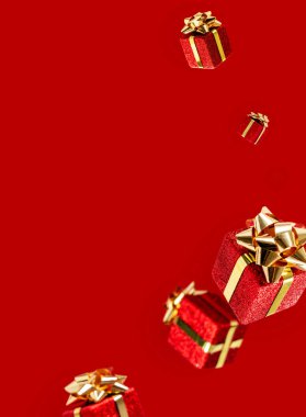 Hediyeler kırmızı arka planda havada uçuşuyor. Satılık. Havalanma konsepti. Kopya alanı olan Noel düzeni.