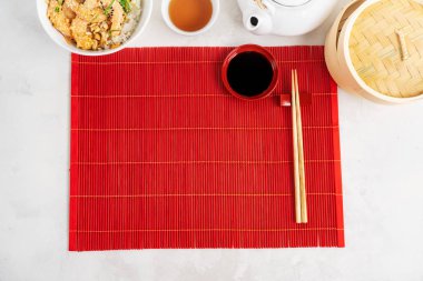 Asya yemekleri. Çaydanlık ve Kupa, Baharatlı Karides Poke Kabı pilav, yosun ve susam tohumları, avokado, buharlı buharlı tencere kırmızı bambu Mat arka planında, gri taş zemin üzerinde yemek çubuklarıyla fotokopi alanı. 