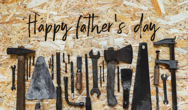 Concept for the Happy Father\'s Day holiday. Old vintage carpenter\'s construction tools on a wooden surface.