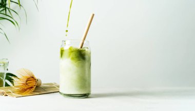 Japon usulü kibrit sütlü latte, sütlü yeşil çay, soya sütü, geleneksel kibrit araçları, beyaz arka planda bambu pipetli..