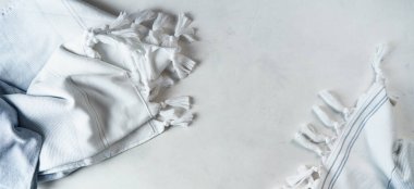 Yumuşak terli havlu, ışık arkaplanındaki çerçevenin kenarlarında zıt çizgiler ve püsküller bulunan pamuk ve ketenden yapılmıştır. Ev konforu tarzı. 