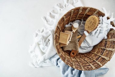 Vücut bakımı için banyo aksesuarları yumuşak beyaz havluyla muz yapraklarından yapılmış bir sepete konur. Ev gibi rahat bir köy tarzı. Doğal ve organik ürünler. güzellik tedavisi