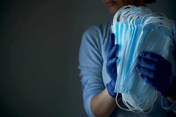 Kobieta Trzyma Stos Masek Ochronnych Twarz Lateksowych Rękawiczkach Jednorazowego Użytku — Zdjęcie stockowe