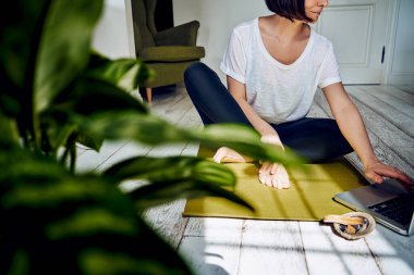 Evde karantinada yoga yapan bir kadın. Ulusal yoga günü. Kilit altında sağlıklı bir yaşam. Meditasyon palo santo çubukları kullanılıyor..
