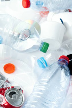 Beyaz arkaplandaki yiyecek plastik ambalaj atığı koleksiyonuna yakından bak. Plastik ve metali geri dönüştürme kavramı. Ekoloji ortamı. Düz konum, kopyalama alanı olan üst görünüm.