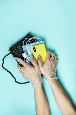 İzolasyon sona erdi ama salgın sona ermedi. Önlem almayı unutma. Karantinadan çıkıyorum. Takı yüzüklü şık bir kız. Ellerinde çanta tutan tek kullanımlık eldivenler var. Yeni gerçeklik.