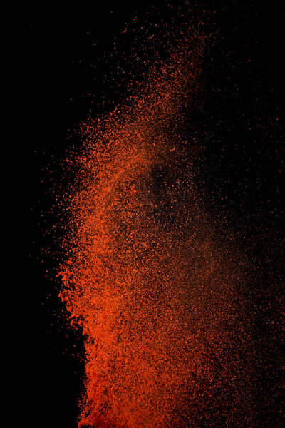 Взрыв специй красной паприки, летящий перец чили изолирован на черном фоне. Всплеск фона специй
. 