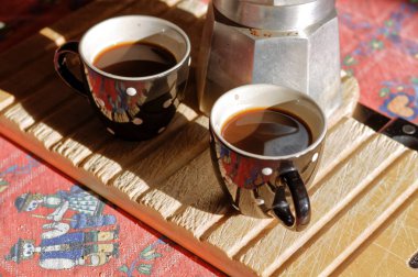 İki bardak kahve cezve ve ahşap kesme tahtası mutfakta closeup odaklanmak.