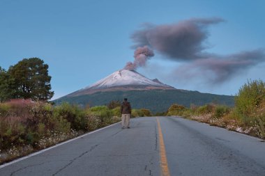 Young man on the road to Popocatepetl volcano clipart