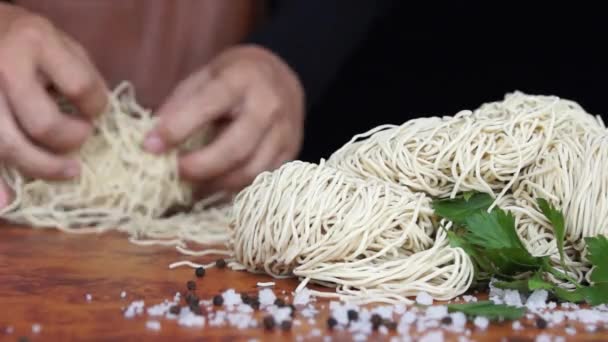 De fokuserade utsikt över en Cooks hand prepping en rulle av Ramen innan han skålla det i varmt kokande vatten — Stockvideo