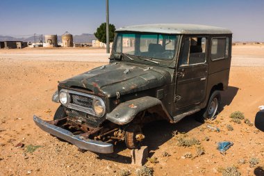 An abandoned vintage SUV in an unnamed small settlement near the Makkah Al Mukarramah Road